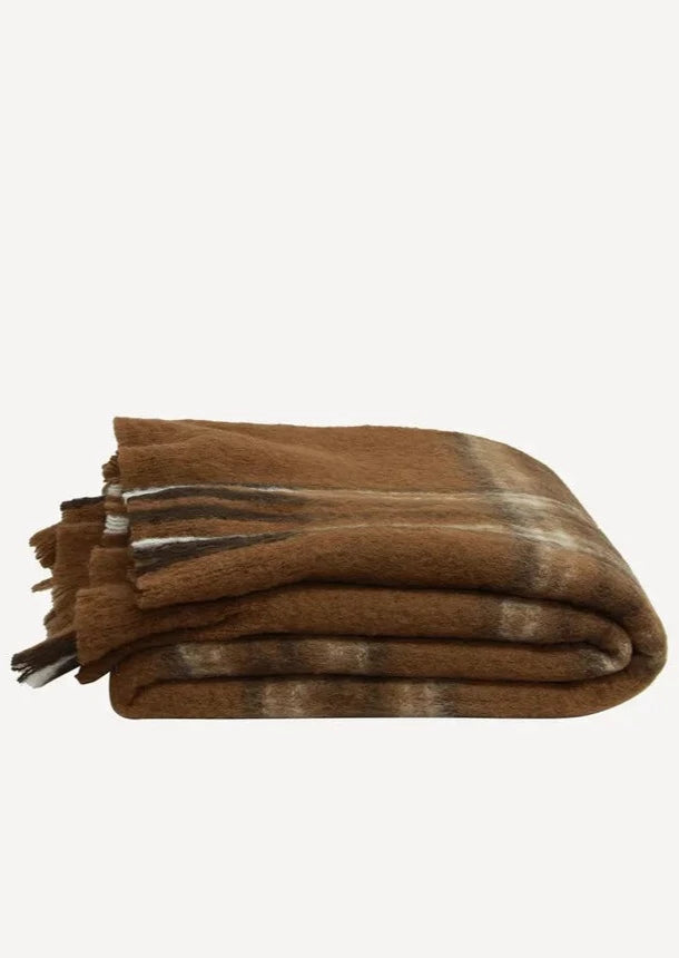 folded brown throw with tassels