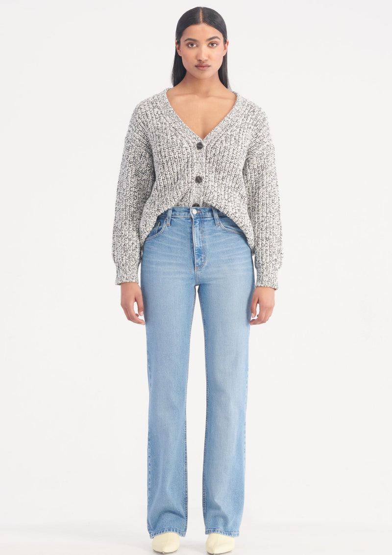 woman wearing blue wash high rise boot cut jeans and grey cardigan